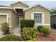 Close up of the front door and landscaping of the tan colored single-Gathering home at 11318 Laurel Brook Ct, Riverview, FL 33569