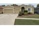 Tan single-Gathering home with a well-maintained lawn and a two-car garage at 11318 Laurel Brook Ct, Riverview, FL 33569