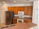 Kitchen with stainless steel refrigerator, white appliances, and wood cabinets at 11318 Laurel Brook Ct, Riverview, FL 33569