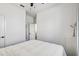 Minimalist bedroom featuring a queen bed, white walls, dark wood floors and a doorway to another room at 11422 Calusa Trails Way, Riverview, FL 33569