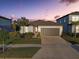 Charming single-story home featuring a two-car garage, a well-manicured lawn, and tropical landscaping at 11422 Calusa Trails Way, Riverview, FL 33569