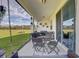 Comfortable covered patio with outdoor seating area and beautiful views of the grassy field beyond at 11422 Calusa Trails Way, Riverview, FL 33569