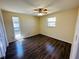 Bright bedroom with dark wood-look floors, ceiling fan, and two windows at 12054 145Th St, Largo, FL 33774