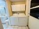 Laundry area featuring a washer, dryer, storage cabinets, and access to the bathroom at 12054 145Th St, Largo, FL 33774