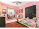 Whimsical pink bedroom with a cozy window seat and hardwood floors at 13403 Bolton Ct, Spring Hill, FL 34609