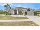 Charming single-story home with arched entry, well-maintained landscaping, and a two-car garage at 13403 Bolton Ct, Spring Hill, FL 34609