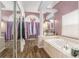 An ensuite bathroom featuring a soaking tub, tile flooring, and lots of natural light at 13403 Bolton Ct, Spring Hill, FL 34609
