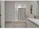 Bright bathroom featuring a shower with tiled walls and glass door, complemented by a decorative rug at 17006 Wave Tressle Pl, Wimauma, FL 33598