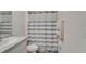 Well-lit bathroom showcasing a shower with a striped curtain, sink, and fresh towels at 17006 Wave Tressle Pl, Wimauma, FL 33598