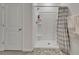 Clean bathroom featuring a shower with tiled walls and glass door, complemented by a decorative rug at 17006 Wave Tressle Pl, Wimauma, FL 33598