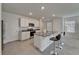 Bright kitchen features an island with bar seating, stainless steel appliances, and granite countertops at 17006 Wave Tressle Pl, Wimauma, FL 33598