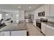 Bright kitchen with stainless steel appliances, granite counters, white cabinetry, and island with sink at 17006 Wave Tressle Pl, Wimauma, FL 33598