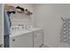 Functional laundry room with modern washer and dryer, and storage space with white walls at 17006 Wave Tressle Pl, Wimauma, FL 33598