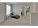 This is an upstairs loft with a chaise lounge, glass side table, and open doors to the workout room and another bedroom at 17006 Wave Tressle Pl, Wimauma, FL 33598