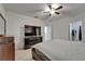 This bedroom features a ceiling fan, a large TV on a dresser and a walk in closet at 17006 Wave Tressle Pl, Wimauma, FL 33598