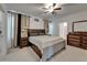 This is a view of a main bedroom that is decorated in neutral colors with a dark wood bedroom suite at 17006 Wave Tressle Pl, Wimauma, FL 33598