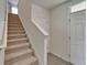 Carpeted staircase with white banister leading to the upper level, adjacent to the front door at 17006 Wave Tressle Pl, Wimauma, FL 33598
