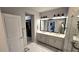 Modern bathroom with double vanity, stylish lighting, and an open doorway to a walk-in closet at 17212 Balance Cv, Land O Lakes, FL 34638