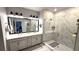 Modern bathroom with a glass-enclosed shower, dual sinks, and sleek lighting fixtures at 17212 Balance Cv, Land O Lakes, FL 34638