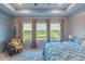 Bright bedroom with a large window view, comfortable seating, and elegant curtains at 17212 Balance Cv, Land O Lakes, FL 34638