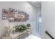 Light-filled hallway with Gathering photos, a decorative table, and access to other rooms at 17212 Balance Cv, Land O Lakes, FL 34638