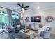 Bright living room has comfortable seating, a ceiling fan, neutral decor, and access to the outdoors at 17212 Balance Cv, Land O Lakes, FL 34638