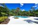 A pristine community pool surrounded by palm trees and lush foliage creates a tranquil and relaxing atmosphere at 17212 Balance Cv, Land O Lakes, FL 34638