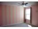 Bedroom with candy striped accent wall, carpet, and ceiling fan at 17833 Althea Blue Pl, Lutz, FL 33558