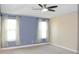 Well lit bedroom with ceiling fan, neutral paint and window with semi sheer curtains at 17833 Althea Blue Pl, Lutz, FL 33558