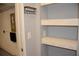 Image of gray hallway with shelf storage, white trim and a hook rack at 17833 Althea Blue Pl, Lutz, FL 33558