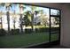 Screened-in patio with views of lush landscaping including palm trees and grassy lawn at 17833 Althea Blue Pl, Lutz, FL 33558