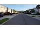 Neighborhood street view of condos featuring palm trees, sidewalks and well-maintained lawns at 17833 Althea Blue Pl, Lutz, FL 33558