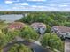 Aerial view of a home with tile roof, lush landscaping, and lake views at 1804 Bella Casa Ct, Tampa, FL 33618