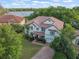 Overhead view of home featuring tile roof, mature landscaping, and view of community and lake at 1804 Bella Casa Ct, Tampa, FL 33618