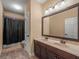 Bathroom featuring double sinks, dark cabinets, and a shower with a dark shower curtain at 1804 Bella Casa Ct, Tampa, FL 33618