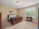 Bedroom with a queen bed and large window with plantation shutters at 1804 Bella Casa Ct, Tampa, FL 33618