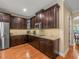 Open kitchen features dark wood cabinets, stainless appliances, granite countertops and wood floors at 1804 Bella Casa Ct, Tampa, FL 33618