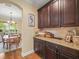 Butler's pantry with dark wood cabinets, granite countertops, and wood floors at 1804 Bella Casa Ct, Tampa, FL 33618