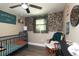 Cozy Bedroom featuring colorful wallpaper, a comfortable rocking chair, and a crib at 1920 30Th E Ave, Bradenton, FL 34208