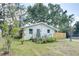 Exterior shot of home with blue door, lush lawn, and a wood fence at 1920 30Th E Ave, Bradenton, FL 34208