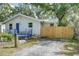 Inviting home exterior with a blue porch, complemented by mature trees and a freshly stained, wooden fence at 1920 30Th E Ave, Bradenton, FL 34208
