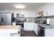Bright kitchen featuring stainless appliances, granite countertops, white cabinetry, and a stylish tile backsplash at 1920 30Th E Ave, Bradenton, FL 34208