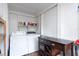 Functional laundry room with washer, dryer, shelving, and folding table at 1920 30Th E Ave, Bradenton, FL 34208
