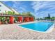 Inviting community pool area with pergola, lounge chairs, and manicured landscaping at 223 Island Way # 5E, Clearwater Beach, FL 33767