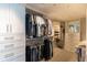 Organized walk-in closet with custom shelves, drawers, mirrored cabinet, and hanging rods for ample clothing storage at 223 Island Way # 5E, Clearwater Beach, FL 33767