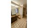 Bathroom featuring tile flooring, wood cabinets, an undermount sink, and a shower-tub combo at 23059 Geneva Rd, Land O Lakes, FL 34639