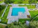 Aerial view of community pool with lounge chairs, umbrellas, and green landscaping at 23059 Geneva Rd, Land O Lakes, FL 34639
