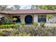 Inviting front entry with a double blue door, colorful landscaping, and manicured shrubs at 23059 Geneva Rd, Land O Lakes, FL 34639