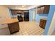 Open kitchen with tile flooring, wood cabinets, black appliances, and a breakfast bar at 23059 Geneva Rd, Land O Lakes, FL 34639