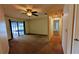 Spacious living room with sliding glass doors leading to the screened-in pool area, ceiling fan, and carpet flooring at 23059 Geneva Rd, Land O Lakes, FL 34639